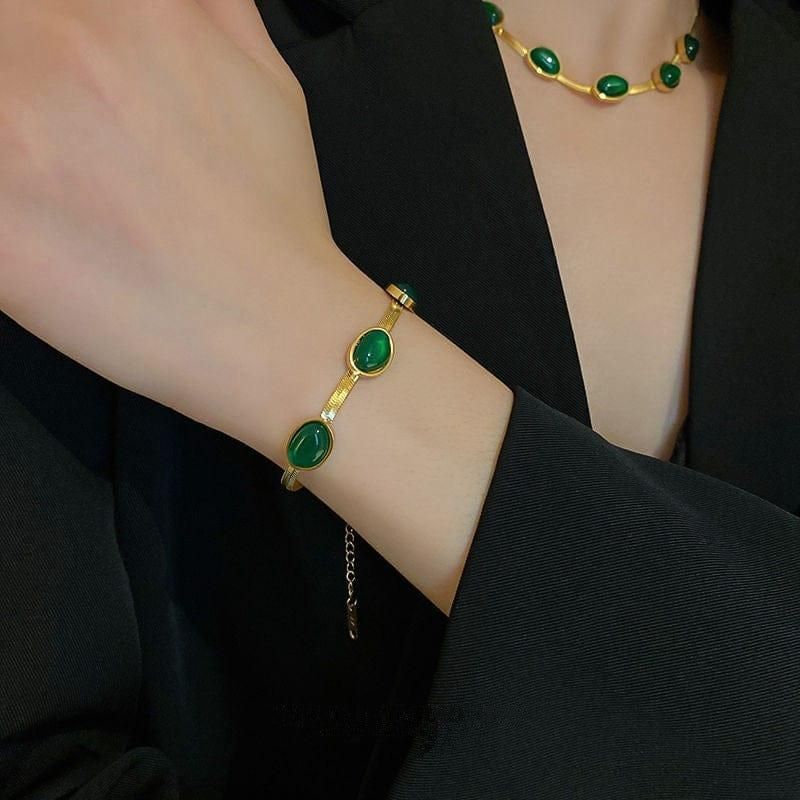Stylish gold necklace and bracelet set with oval green crystal for women